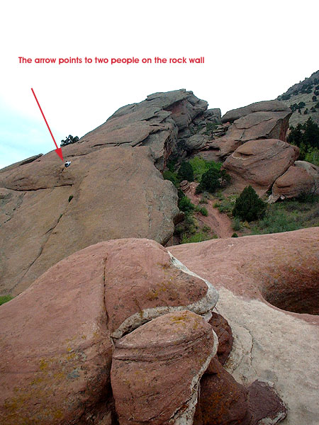 Big rock wall with two people climbing it.jpg 98.9K